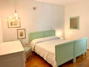 1 dormitorio con 1 cama y 1 silla en MICASA ESTUCASA slow holiday, en Padergnone