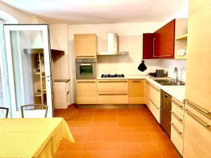 cocina con armarios de madera y suelo de baldosa naranja en MICASA ESTUCASA slow holiday, en Padergnone