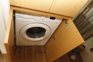 a washer and dryer in a cabinet in a kitchen at Casa com pátio-São Lourenço-Ericeira in Casais de São Lourenço