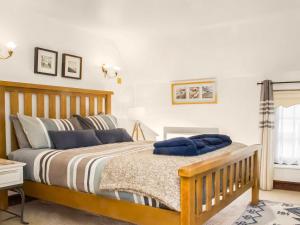 a bedroom with a wooden bed and a window at Whitestones Cottage in Caister-on-Sea