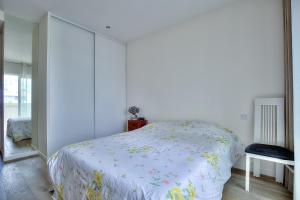 a bedroom with a bed with a floral bedspread at Le Florentina, dernier étage avec terrasse, vue sur la Baie des Anges in Nice