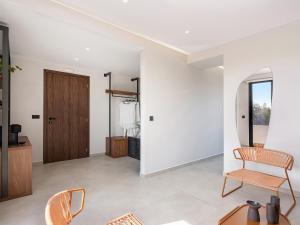 a living room with a wooden door and chairs at Theta Boutique Hotel in Chania