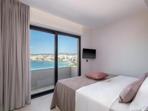 ein Schlafzimmer mit einem Bett und einem großen Fenster in der Unterkunft Theta Boutique Hotel in Chania