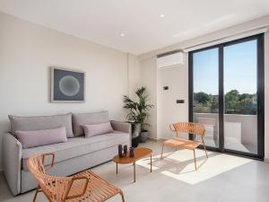 - un salon avec un canapé, une table et des chaises dans l'établissement Theta Boutique Hotel, à La Canée