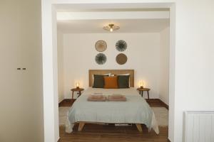 a bedroom with a bed with two pillows on it at Casa com pátio - São Lourenço (Ericeira) in Casais de São Lourenço