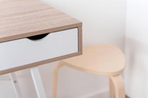 uma mesa de madeira com um banco branco ao lado de uma mesa em GuestReady - Magnolia Apartments - Studio 2 no Porto