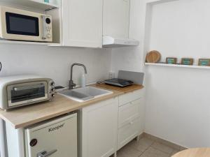 a small kitchen with a sink and a microwave at CASA DIVINO in Bari