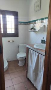 ein Bad mit einem WC und einem Waschbecken in der Unterkunft Chalet con piscina privada, natural y acogedor in Chiclana de la Frontera