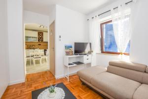 a living room with a couch and a tv at Apartment Sidro in Pag