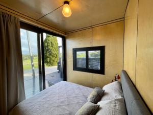 a bedroom with a bed and a large window at Waitomo Retreat in Hangatiki