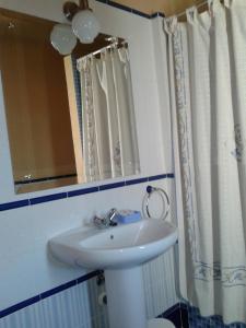 ein Badezimmer mit einem weißen Waschbecken und einem Spiegel in der Unterkunft Casa Rural La Vallejera in Tejeda de Tiétar