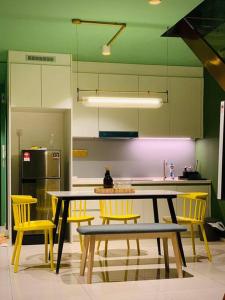 a kitchen with yellow chairs and a table and a counter at EkoCheras Residences Van Gogh theme design with MRT Cheras in Kuala Lumpur