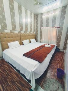 a bedroom with a large bed with a brown blanket at Hotel India inn in Agra