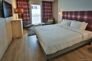 - une chambre avec un grand lit blanc dans l'établissement Hôtel Le Refuge des Sources, à Digne-Les-Bains