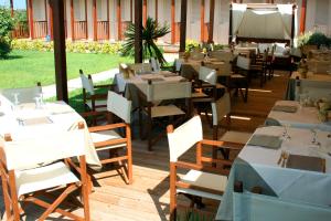 a restaurant with tables and chairs on a wooden deck at Hotel La Pigna in Marina di Pietrasanta