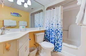 a bathroom with a toilet and a sink and a shower at 0102 Beach It by Atlantic Towers in Carolina Beach