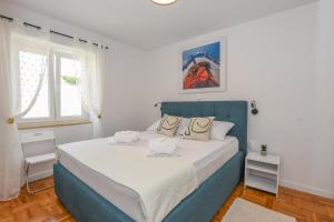 a bedroom with a large bed with a blue headboard at Apartment Sidro in Pag