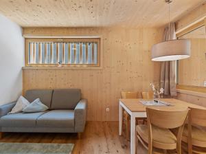a living room with a couch and a table at Neues Wood Design Apartment im Herzen des Bregenzerwalds in Mellau