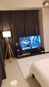un soggiorno con TV a schermo piatto in una camera da letto di 101 Newport blvd C2 4F by Rechelle Nunag a Manila