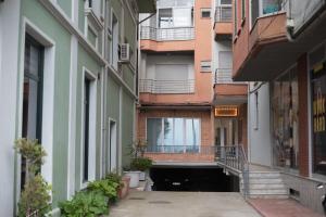 an alley between two buildings with balconies at Comfort Rooms Pogradec in Pogradec
