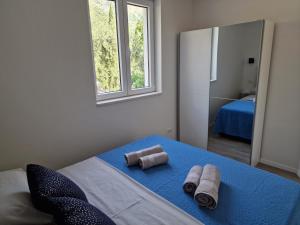 um quarto com duas toalhas numa cama com um espelho em Summerhouse Liber em Mlini