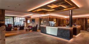 a lobby with wood paneling and a reception counter at Dolmites Nature Hotel Vigilerhof in Siusi