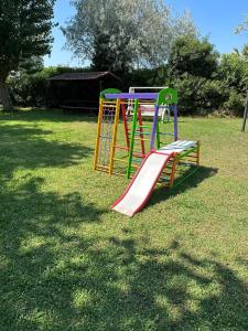 a playground with a slide in the grass at Hotel St Gregory Park in Rimini