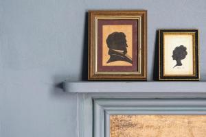two framed pictures on top of a fireplace at Bath's Most Illustrious Address - Garden Apartment in Bath