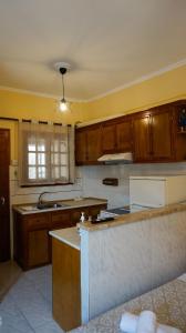 a kitchen with wooden cabinets and a counter top at SOULA ROOMS in Kini