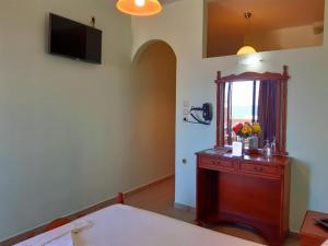 Borianoula Apartments في فراي: غرفة مع خزانة ملابس مع نافذة وتلفزيون