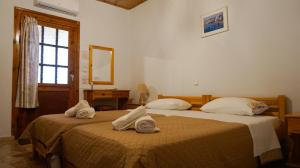 two beds in a room with towels on them at SOULA ROOMS in Kini