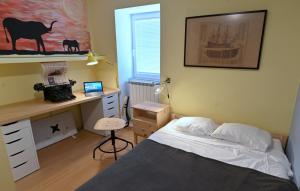 a bedroom with a bed and a desk with a computer at Captain's Cabin Piran - free parking in Piran
