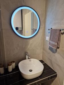 uma casa de banho com um lavatório branco e um espelho. em Summerhouse Liber em Mlini