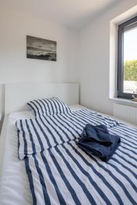 uma cama com um cobertor listrado azul e branco em Ferienwohnung Seebär em Wangerland