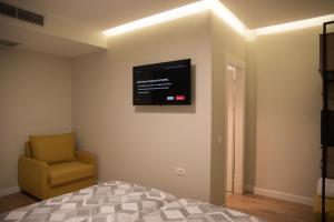 um quarto com uma televisão na parede e uma cadeira em Comfort Rooms Pogradec em Pogradec