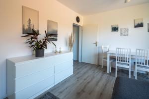 uma sala de estar com uma cómoda branca e uma mesa em Ferienwohnung Seebär em Wangerland