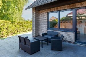 a patio with two chairs and a table and windows at Ferienwohnung Seebär in Wangerland