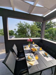 una mesa con platos de comida en el balcón en Summerhouse Liber, en Mlini