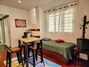 a bedroom with a bed and a table and chairs at EVASION Bungalow d'Antan Spa in Sarraméa