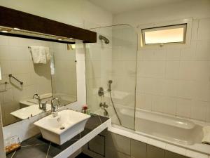 a bathroom with a sink and a shower and a tub at EVASION Bungalow d'Antan Spa in Sarraméa