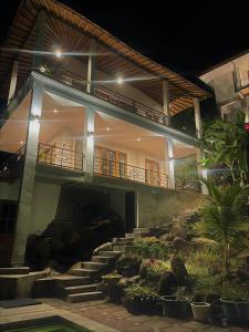 a building with stairs in front of a yard at Private Villa - Ocean, hills, valley view in Temukus