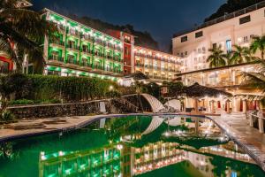 un hôtel avec une piscine en face d'un bâtiment dans l'établissement Cat Ba Island Resort & Spa, à Cat Ba
