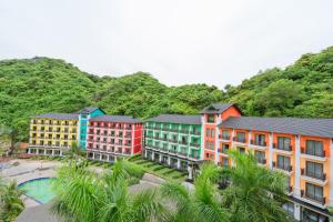 un groupe de bâtiments devant une montagne dans l'établissement Cat Ba Island Resort & Spa, à Cat Ba
