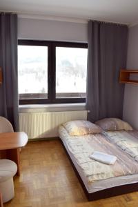 1 dormitorio con 2 camas y ventana en Fazolandia, en Zwardoń