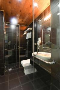 uma casa de banho com uma cabina de duche em vidro e um lavatório. em Kawasaki Noi Bai Hotel em Noi Bai