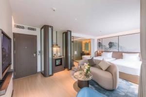 une chambre d'hôtel avec un lit et un canapé dans l'établissement Cat Ba Island Resort & Spa, à Cat Ba