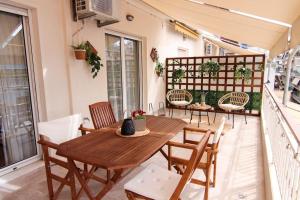 un patio con tavolo e sedie in legno sul balcone. di Πολυτελές διαμέρισμα-Πασαλιμάνι a Pireo