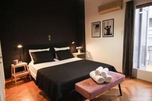 um quarto com uma cama grande e 2 toalhas num banco em Πολυτελές διαμέρισμα-Πασαλιμάνι em Piraeus