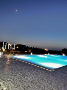 a large blue swimming pool at night at Carrua in Marzamemi