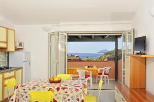 a kitchen and dining room with a table and chairs at Arbatax Le Terrazze sul Mare in Àrbatax